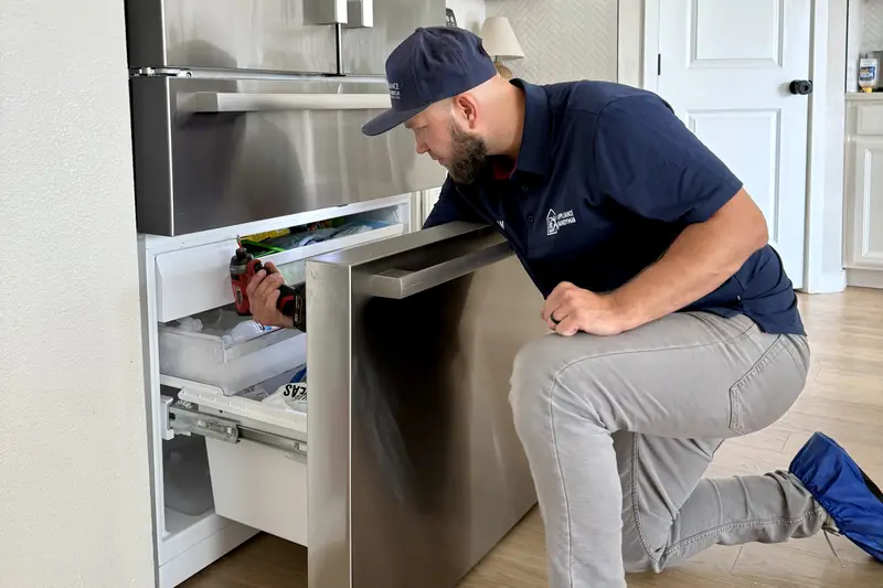 Technician repairing the bottom freezer drawer of a Bosch refrigerator