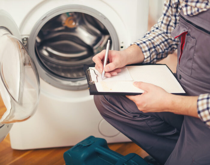 repairman is repairing a washing machine on the white background
